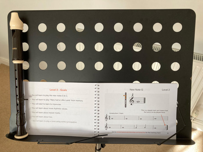 A book and recorder on a music stand