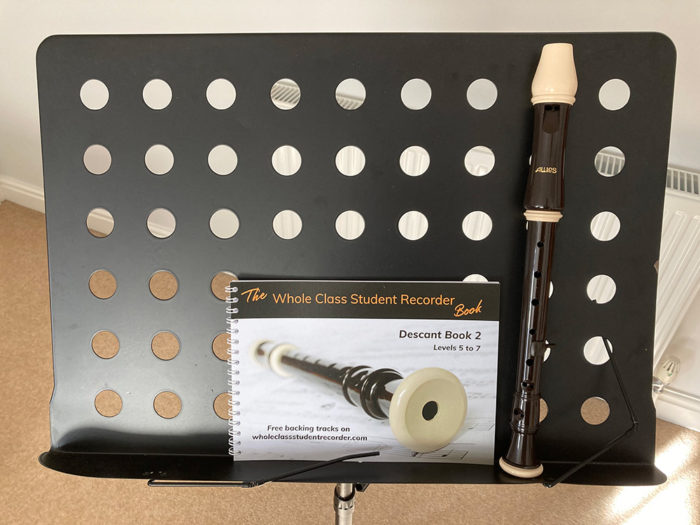 A book and recorder on a music stand