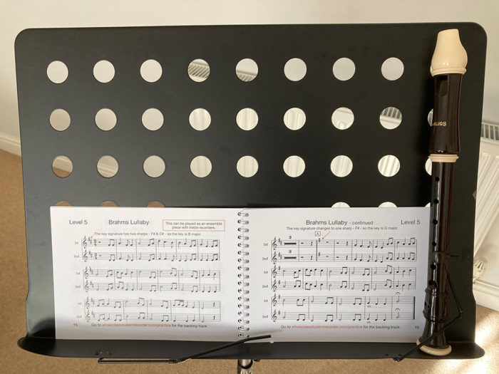 A book and recorder on a music stand