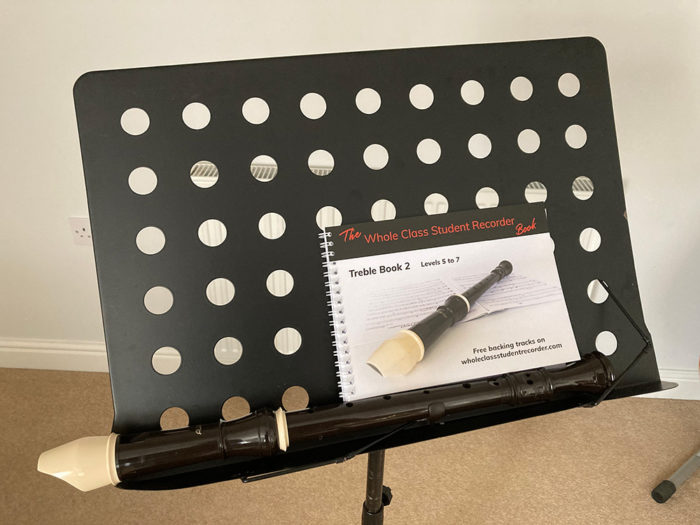 A book and recorder on a music stand