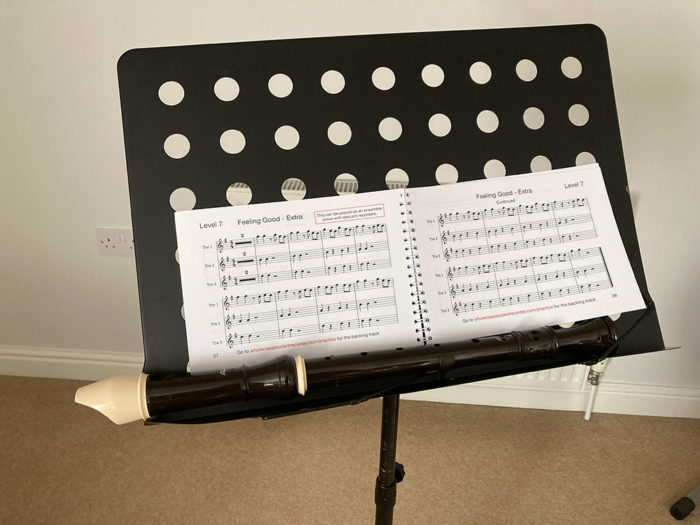 A book and recorder on a music stand